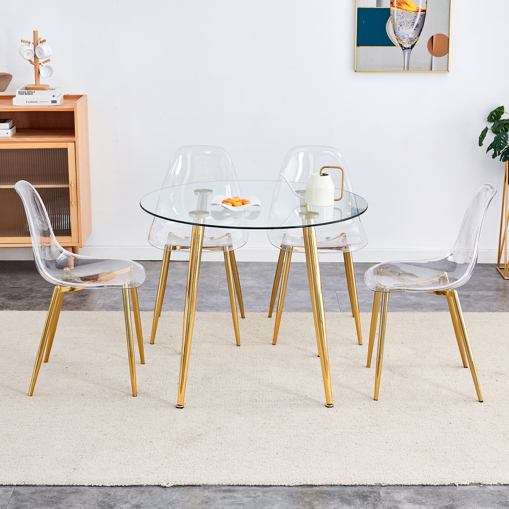 A modern minimalist style round transparent tempered glass table with gold metal legs,paired with 4 modern style transparent dining chairs for a luxurious experience.