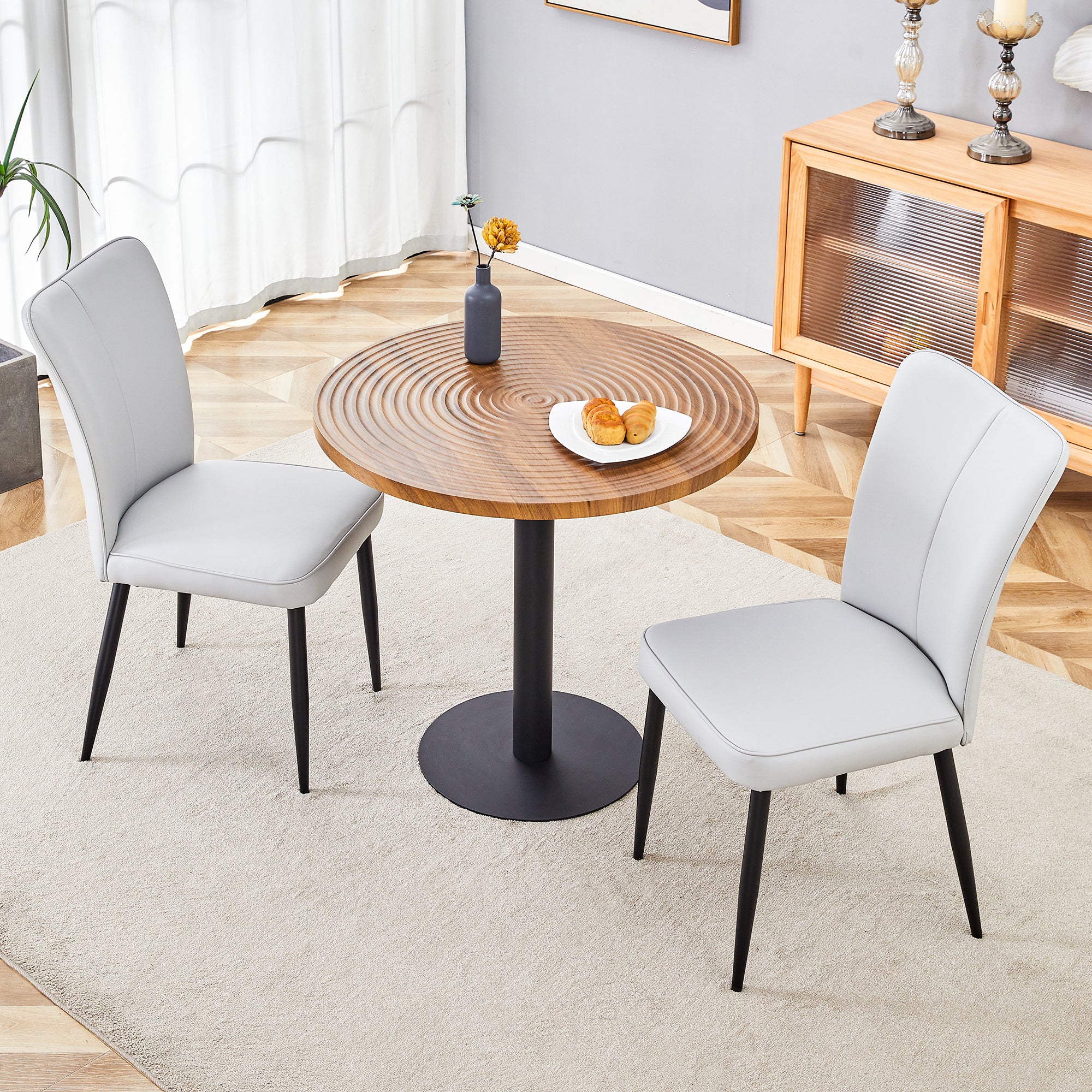Table and chair set.31.5 Inch Dark Wood Grain Round Dining Table - Suction Molding Annular Texture.Paired with 2 Light Gray PU chairs with a vertical stripe design on the backrest.